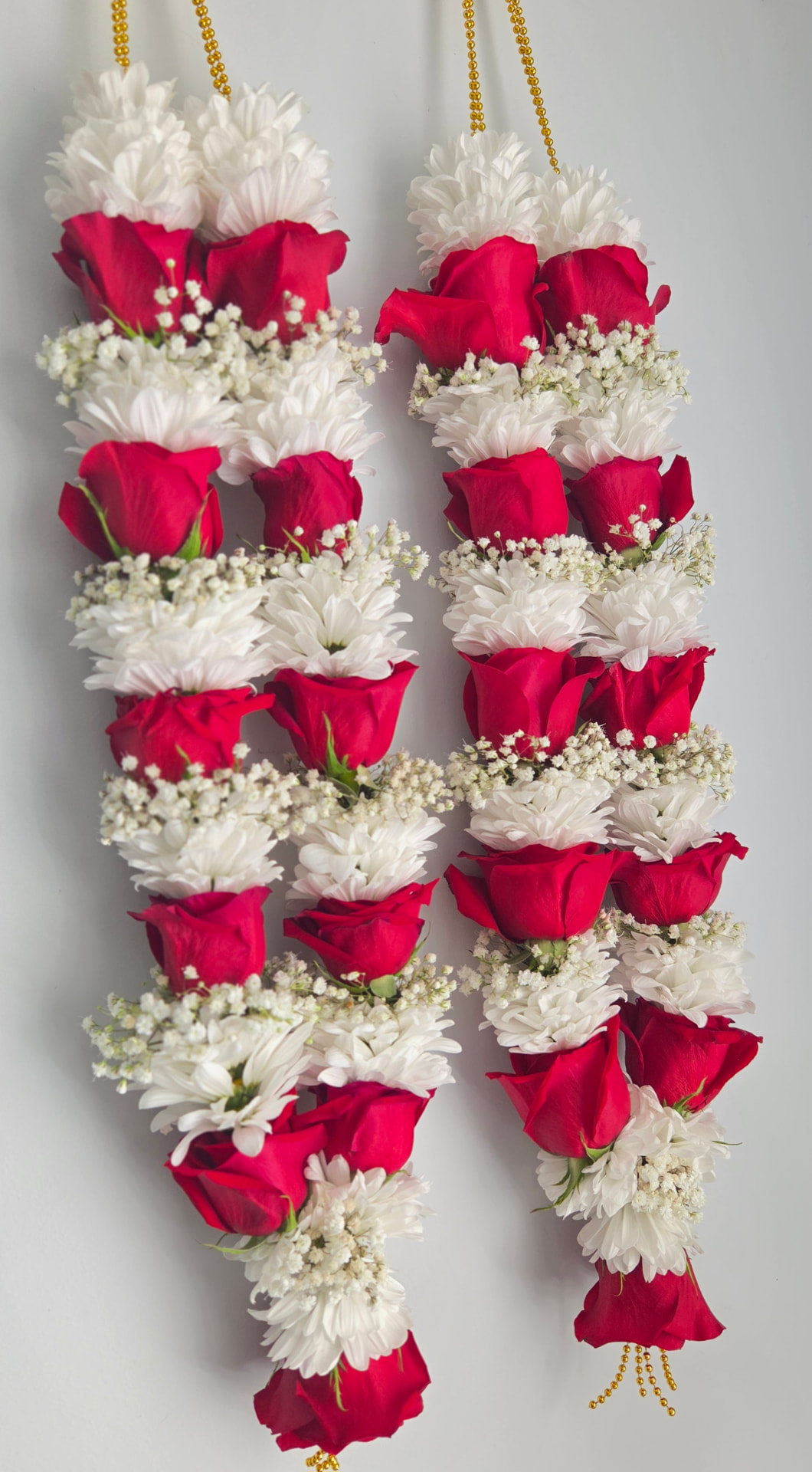 Red rose and white chrysanthemum garland pair with baby's breath and gold tassels