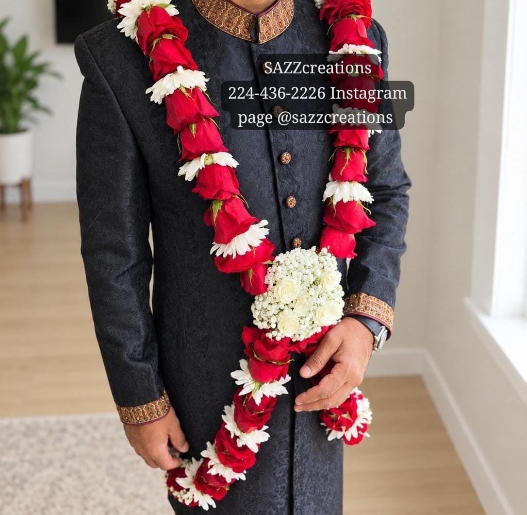 Groom wearing a red rose and white chrysanthemum baddi haar with ivory rose centerpiece