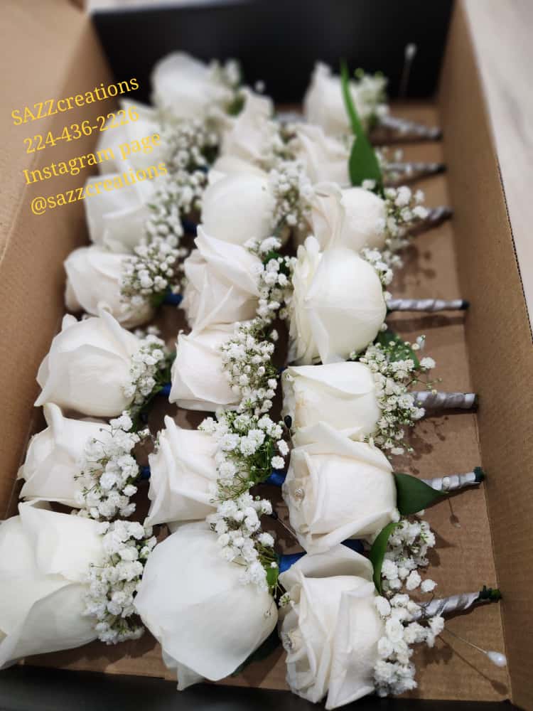 White rose and baby's breath boutonnieres for groomsmen