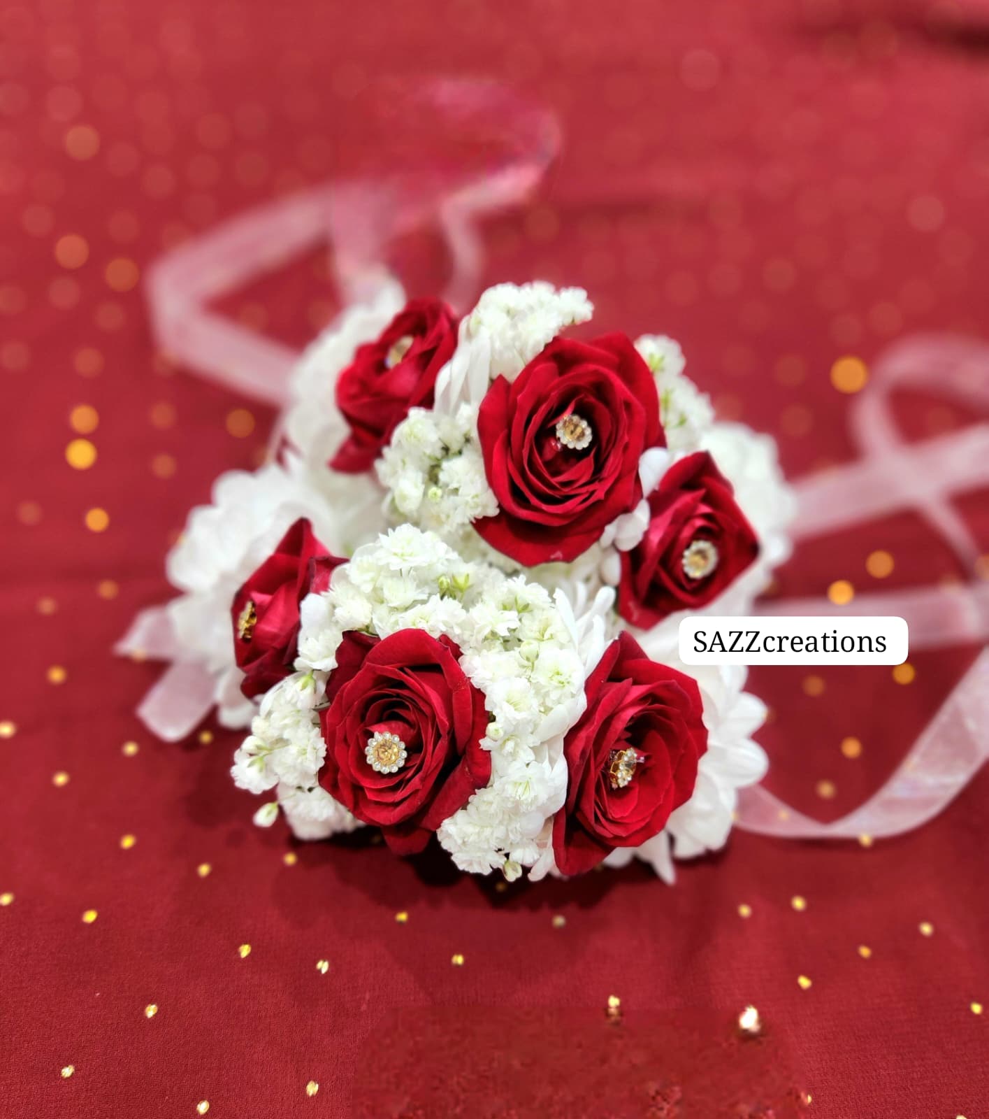 Red rose and white floral wrist bracelets with gold jewel centers and ribbon