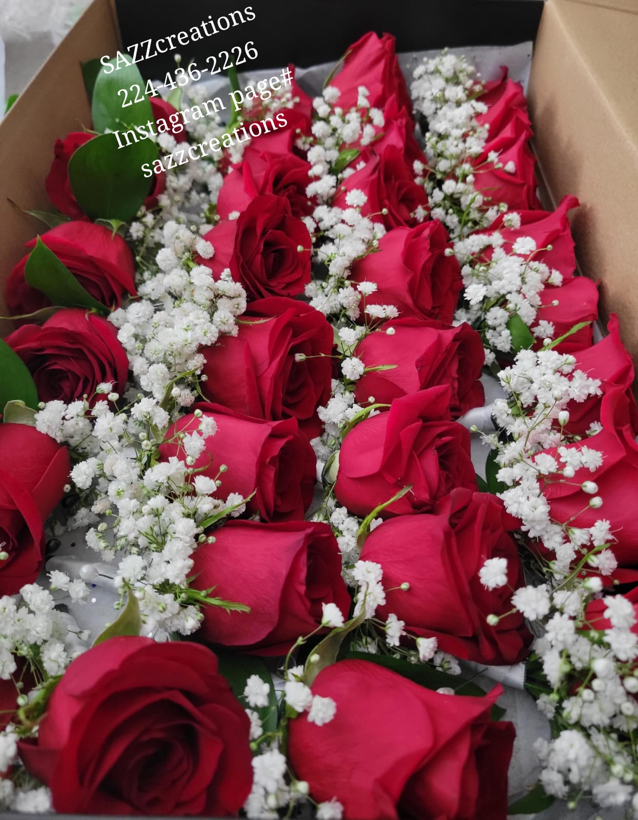 Red rose and baby's breath boutonnieres arranged in a large gift box